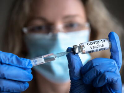 female doctor holds syringe and bottle with vaccine for coronavirus cure